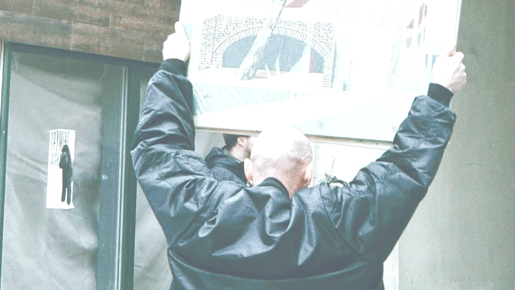 Un uomo solleva un pannello illustrato durante un allestimento